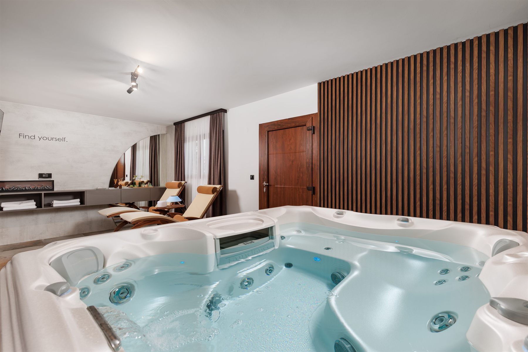SPA prostor s jacuzzijem, drvenim detaljima i toplim ambijentalnim svjetlom.